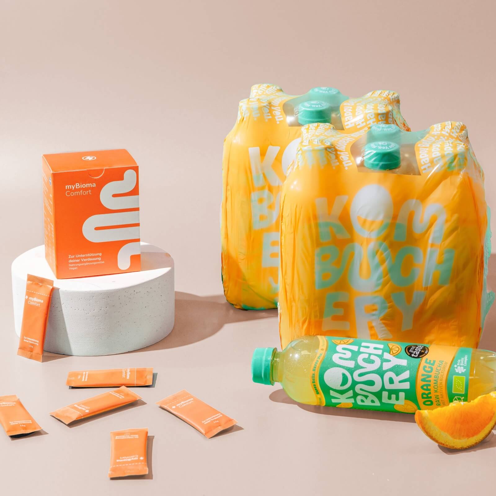 myBioma Comfort neben Flaschen von Kombuchery in der Sorte "Orange"