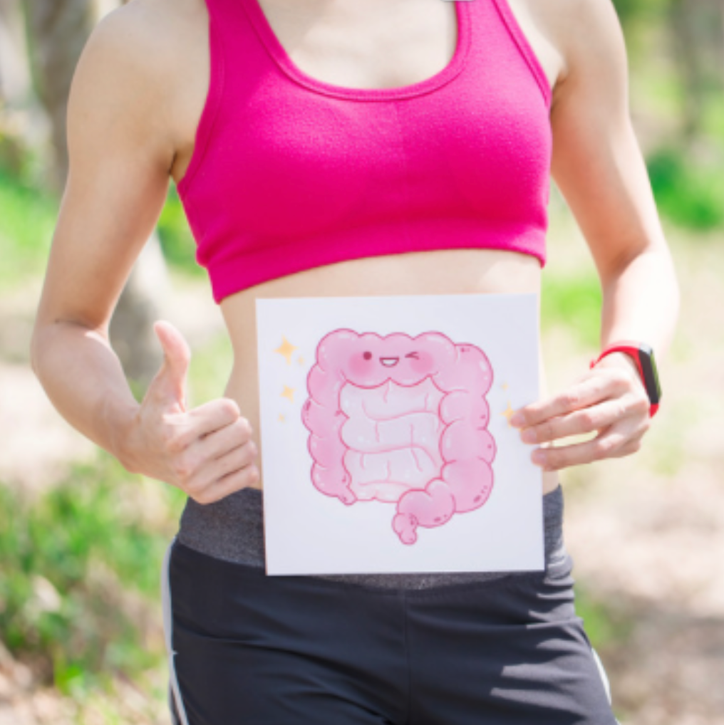 woman in sports cloths holding a drawing of a gut in front of her belly