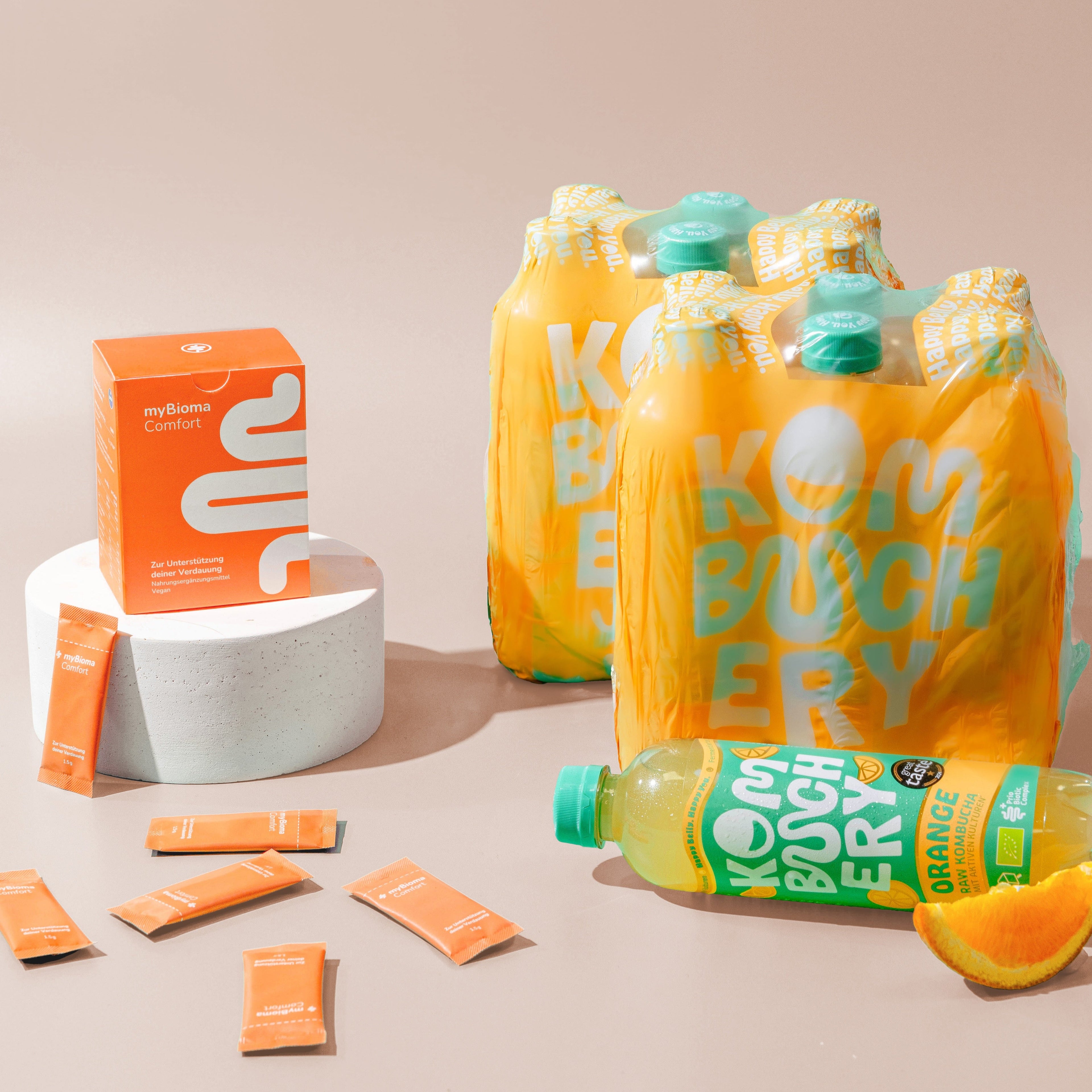 myBioma Comfort neben Flaschen von Kombuchery in der Sorte &quot;Orange&quot;