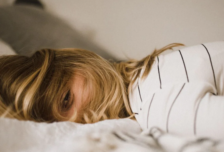 close-up of a woman lying in bed looking tired or maby even depressed